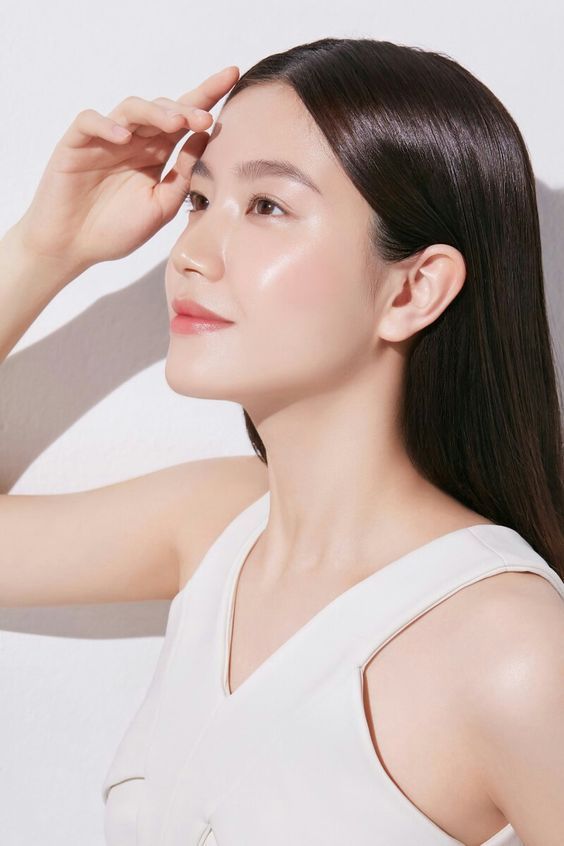 Woman with radiant glowing skin touching face after Pico laser whitening treatment Toronto